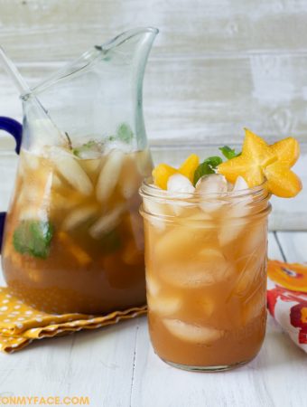 A glass and pitcher filled with Carambola Iced Tea.