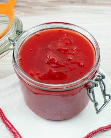 Homemade strawberry sauce in a glass canning jar with a bail type lid.