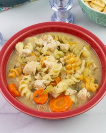 Cajun Chicken Noodle Soup served in a red bowl.